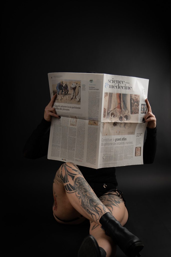 Frau mit Zeitung und Tattoo